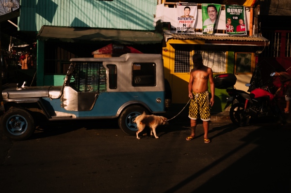 Prints - A man walks his dog in San Andres Bukid. 