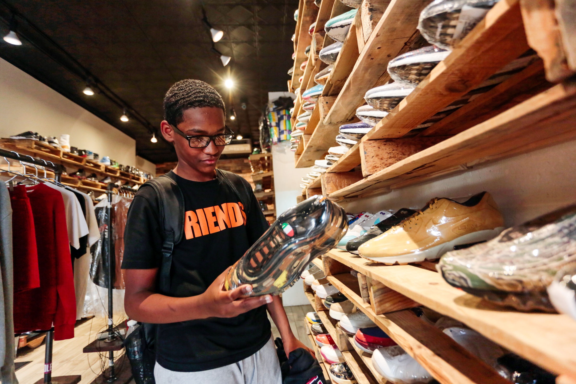 A young shopper browses sneakers at Soled Out, a sneaker...