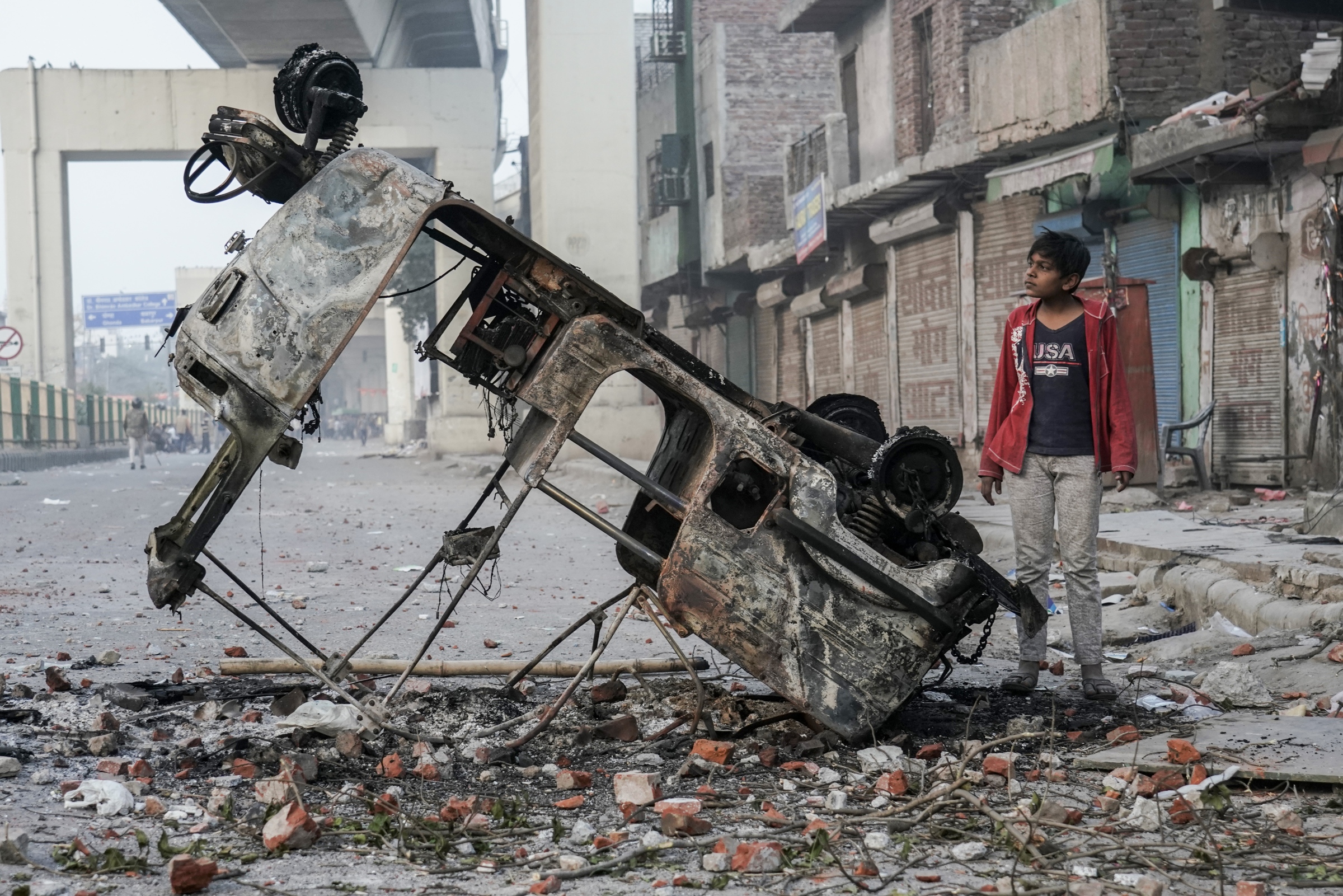  Home - A boy observes an upended vehicle that was charred during the Northeast Delhi riots on Feb. 24, 2020, in Maujpur, Delhi, India. Sectarian division reached its precipice as violence broke out in and around the capital between Hindu nationalists and those in opposition to Prime Minister Modi's Citizen Amendment Act. 