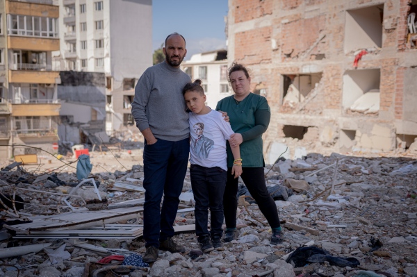  Volkan, Hatice, and Hakan standing on what is left of...