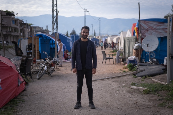Mohammed posing for a portrait in the camp where he lives. 