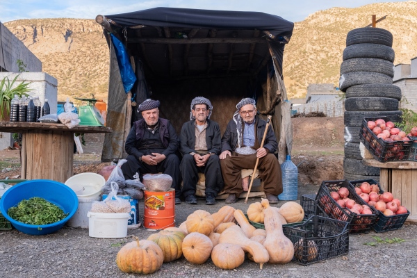 Three friends from Iraqi Kurdistan are sitting together...